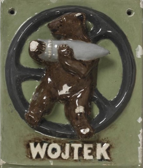 Placa esmaltada 'WOJTEK' com o urso carregando projétil