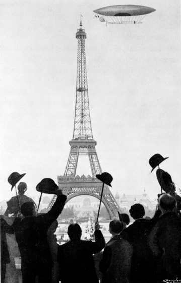 Omschrijving: Alberto Santos-Dumont vaart met een zeppelin langs de Eiffeltoren te Parijs. 1901.
